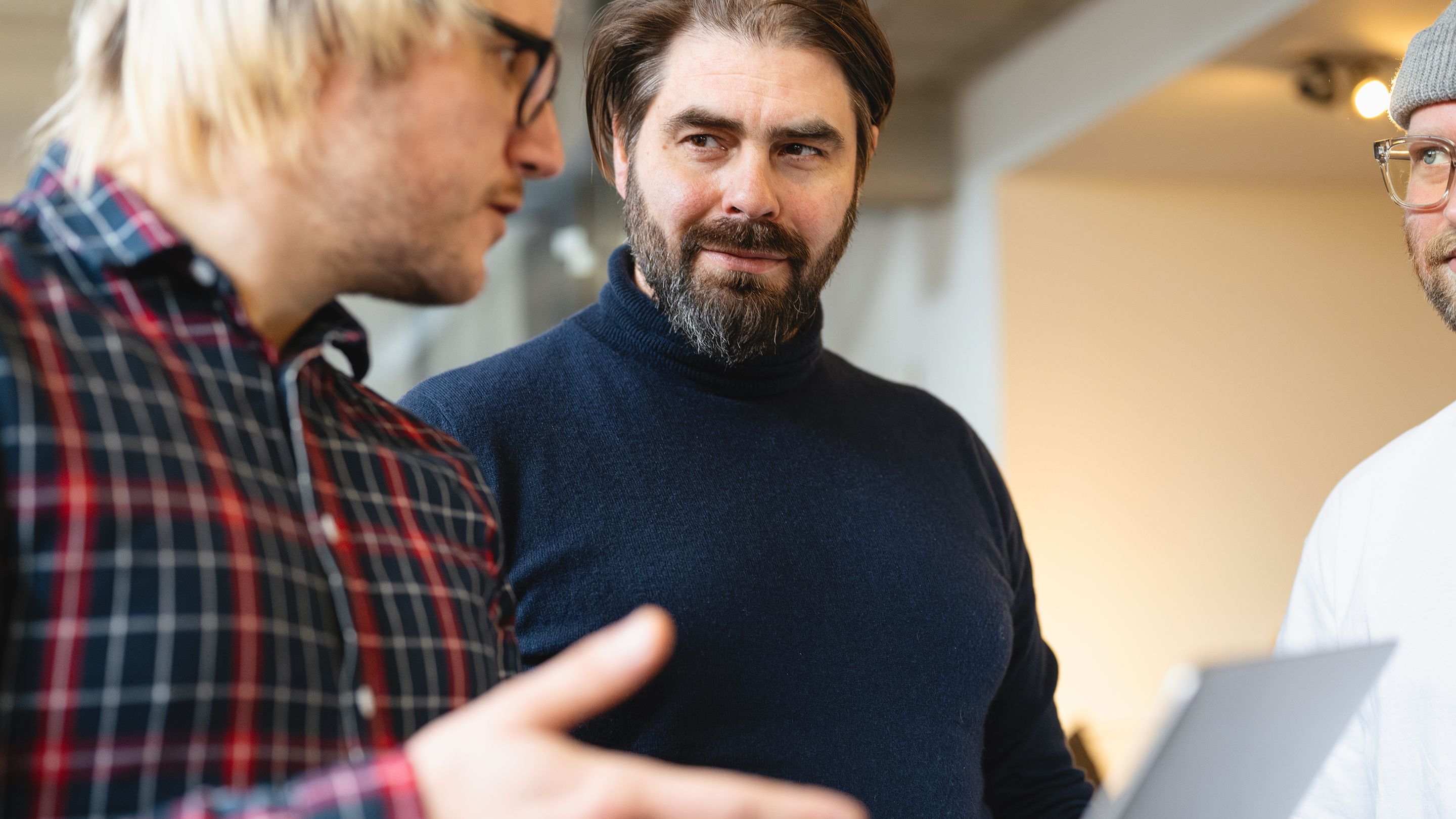 Labor b-Geschäftsführer Thomas Wucherpfennig im Gespräch mit zwei Mitarbeitenden des Screendesign-Teams.